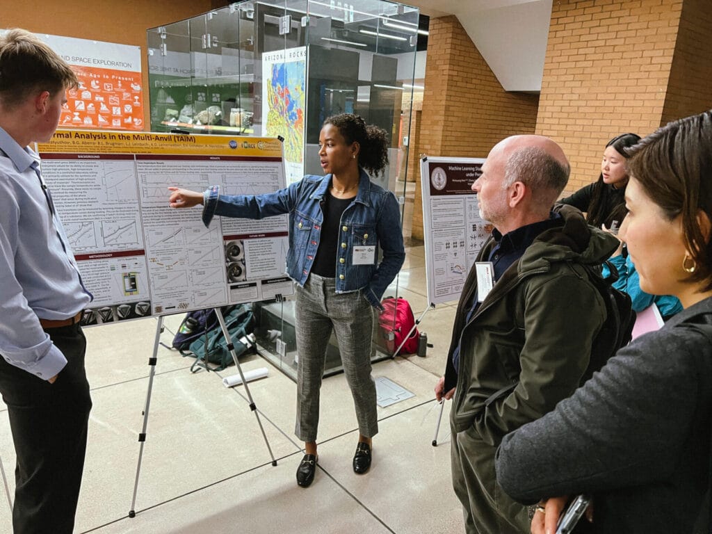Ivan Matyushov, Blaine Aberra, and Minkyung Han present posters to Andy Campbell and Megumi Kawasaki